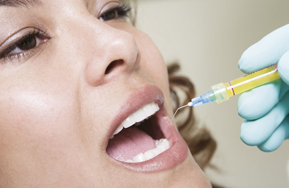 woman getting a shot in her gums for a Root Canal in Seattle, WA
