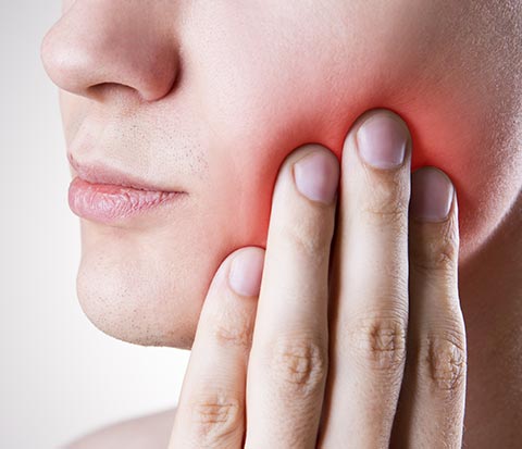 Man holding jaw in pain in need of Emergency Dentist in Shoreline, Seattle