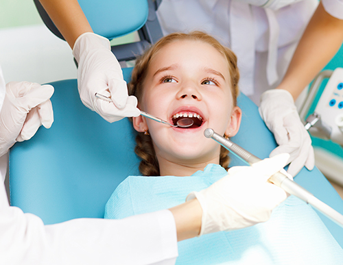 Children's dentist in the middle of a cleaning in Seattle